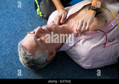 Paramedic using an external defibrillator during cardiopulmonary resuscitation Stock Photo