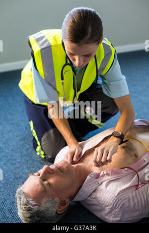 Paramedic using an external defibrillator during cardiopulmonary resuscitation Stock Photo