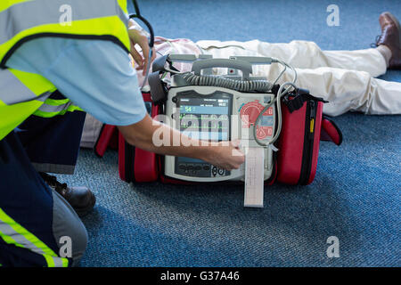 Paramedic using an external defibrillator during cardiopulmonary resuscitation Stock Photo