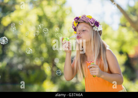 Young girl blowing bubbles through bubble wand Stock Photo