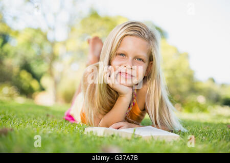 Young girl lying on grass with book Stock Photo
