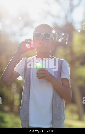 Young boy blowing bubbles through bubble wand Stock Photo