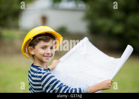 Boy in hard hat holding a plan Stock Photo