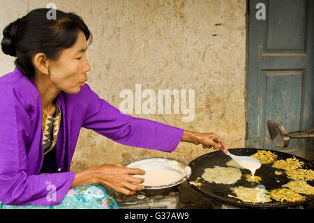 Asia, Myanmar, Loimwe.  Woman walks to bring clothes to wash at the river. Stock Photo