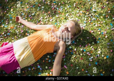 Cute young girl lying on grass in park Stock Photo