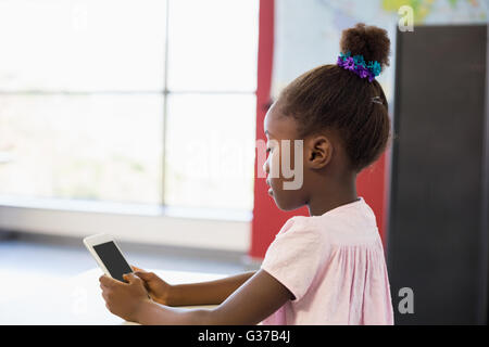 Schoolgirl using mobile phone in classroom Stock Photo