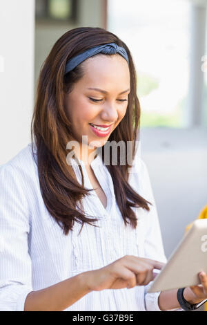 Smiling teacher using digital tablet in classroom Stock Photo
