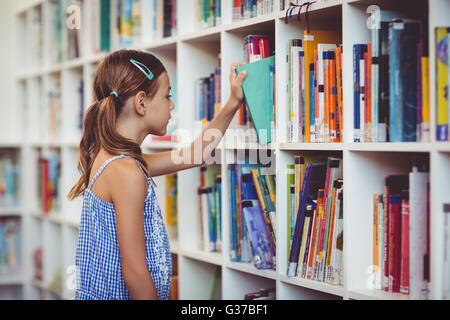 School girl taking a book from bookshelf in library Stock Photo - Alamy