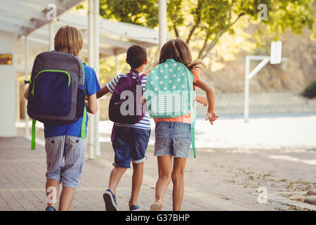Happy school kids running in corridor Stock Photo