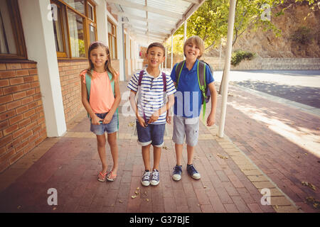 Smiling kids standing together in front of school bus Stock Photo - Alamy