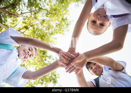 School kids stacking hands in campus Stock Photo - Alamy