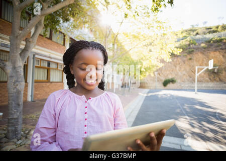 Happy school girl using digital tablet in campus Stock Photo