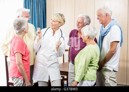 Seniors looking at nurse Stock Photo
