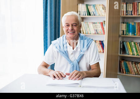 Senior man using braille to read Stock Photo