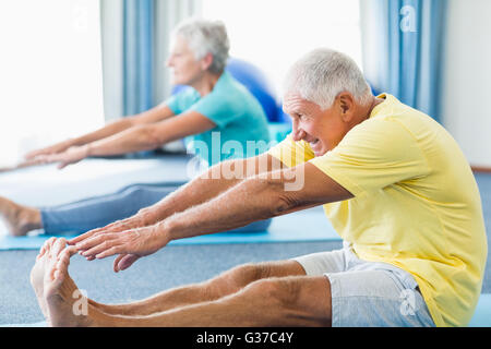 Seniors stretching legs Stock Photo