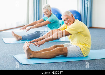 Seniors stretching legs Stock Photo