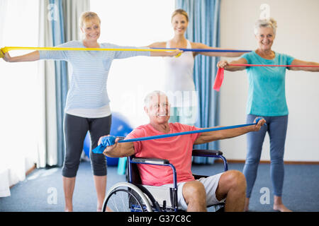 Instructor and seniors exercising with stretching bands Stock Photo