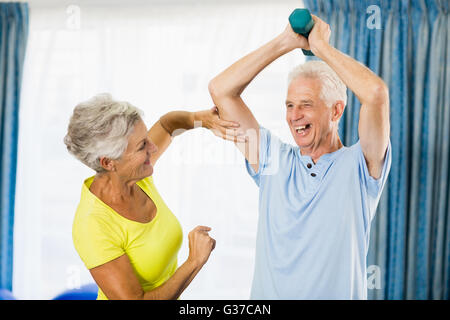 Senior woman feeling muscles of man