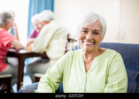 Senior woman sitting on a couch Stock Photo