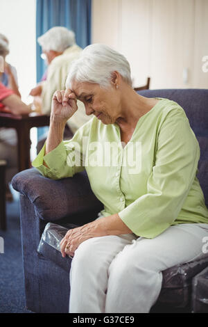 Senior woman sitting on a couch Stock Photo