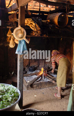 Women Warming by the hearth fire in rural Myanmar Burma, Kengtung, Kyaingtong Stock Photo