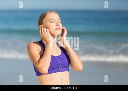 Beautiful young woman listening music while exercising Stock Photo