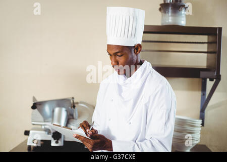 Chef making notes on a clipboard Stock Photo