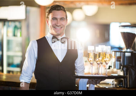 Portrait of waiter holding serving tray with champagne flutesB Stock Photo