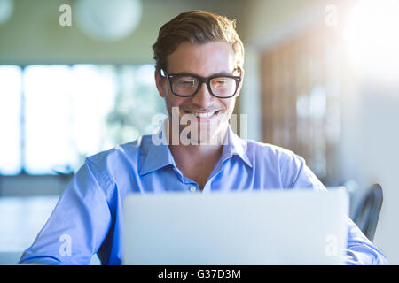 Smiling man using laptop Stock Photo