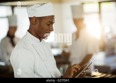 Smiling chef using digital tablet Stock Photo