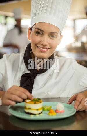 Portrait of female chef finishing dessert plates Stock Photo