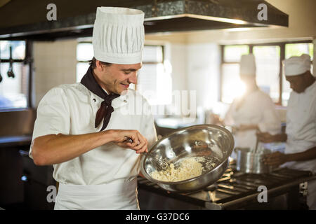 Smiling chef mixing dough Stock Photo