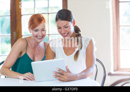 Two smiling women using a digital tablet Stock Photo