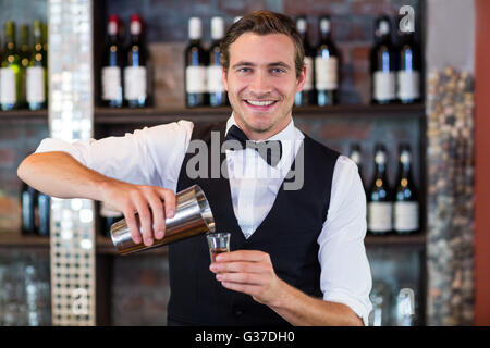 Portrait of bartender pouring tequila into shot glass Stock Photo