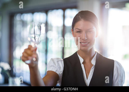 Waitress holding up a empty wine glass Stock Photo