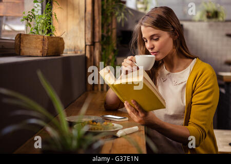 Casual woman reading a book while drinking Stock Photo