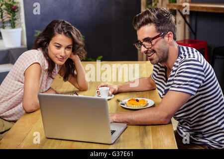 Young couple using laptop in cafeteria Stock Photo