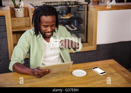 Man drinking coffee and using tablet Stock Photo