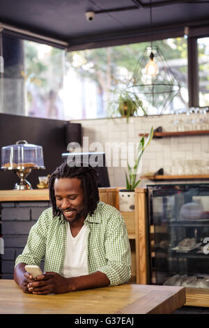 Young man using mobile phone in cafeteria Stock Photo