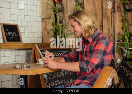 Man using a tablet sitting Stock Photo