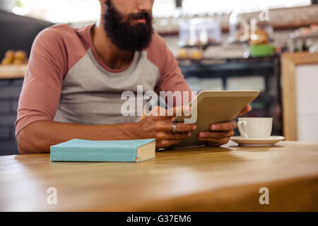 Man using a tablet sitting Stock Photo