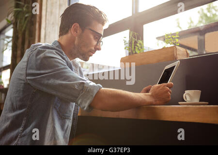 Man using a tablet sitting Stock Photo