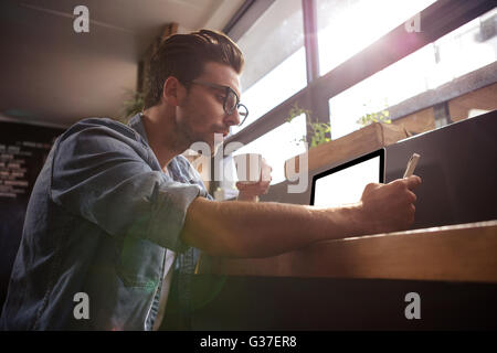 Man drinking coffee and using smartphone Stock Photo