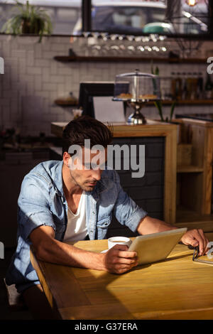 Man using a tablet sitting Stock Photo