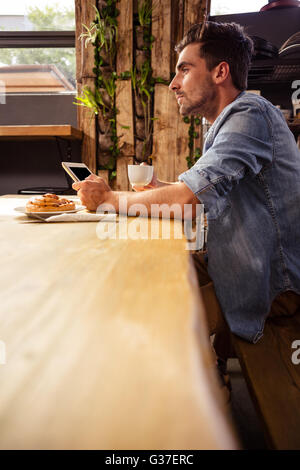 Man drinking coffee and using tablet Stock Photo