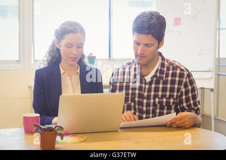 Casual colleagues using a laptop Stock Photo