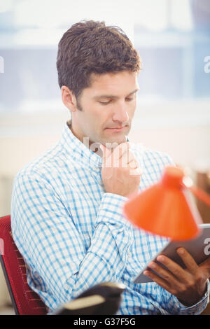 Thoughtful businessman using his tablet Stock Photo