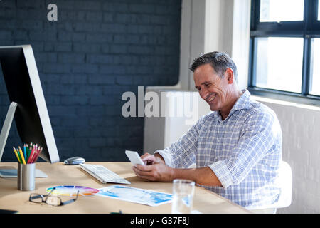 Businessman smiling and using a mobile phone Stock Photo