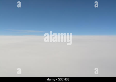 background of blue sky above white clouds as seen from a plane Stock Photo