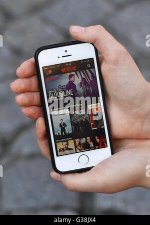 A young woman uses an app by streaming provider Netflix on her smartphone, photographed at the premiere of the Netflix series 'Orange is the new Black - 4th series' in Berlin, 7 June 2016. Netflix is the worldwide leading subscription service for mobile streaming of movies and series. Photo: Jens Kalaene/dpa Stock Photo